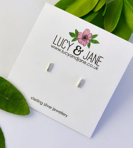 sterling silver dash stud earrings on a white backing card