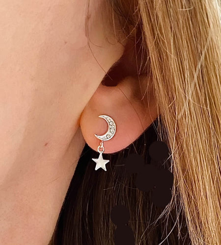 sterling silver moon with star drop earrings on a model's ear