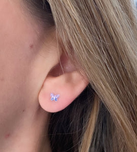 model wearing tiny sterling silver sparkly butterfly studs in purple.